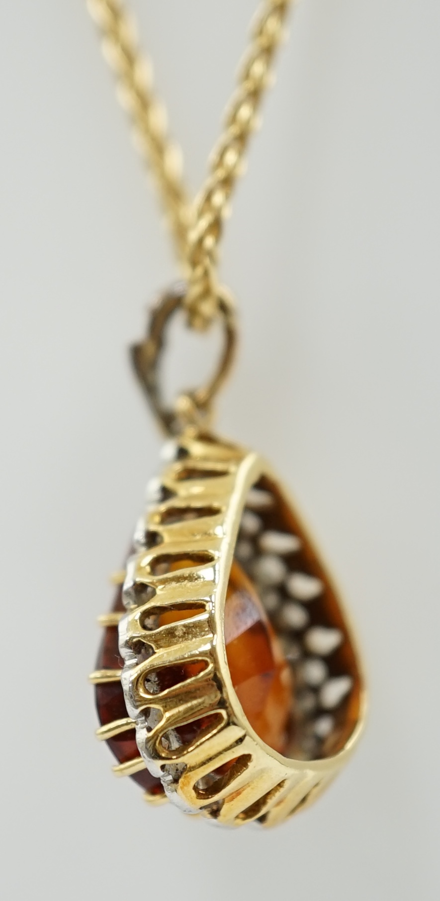 A recent 18k gold, platinum and single stone pear cut citrine pendant, with diamond chip border, on an 18ct gold fine link chain, the pendant with diamond set bale, 24mm, chain 39cm, gross weight 8.5 grams. Condition - f